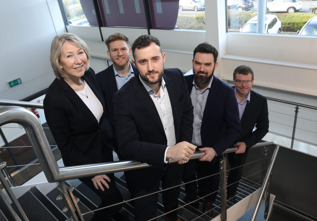 Five people posing for a picture on a flight of stairs