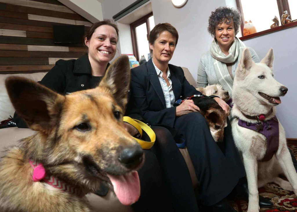 Three people and two dogs posing for a picture