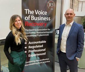 Two people standing in front of a tall banner