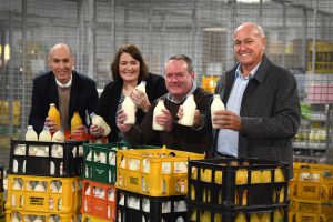 Four people holding up glasses of milk